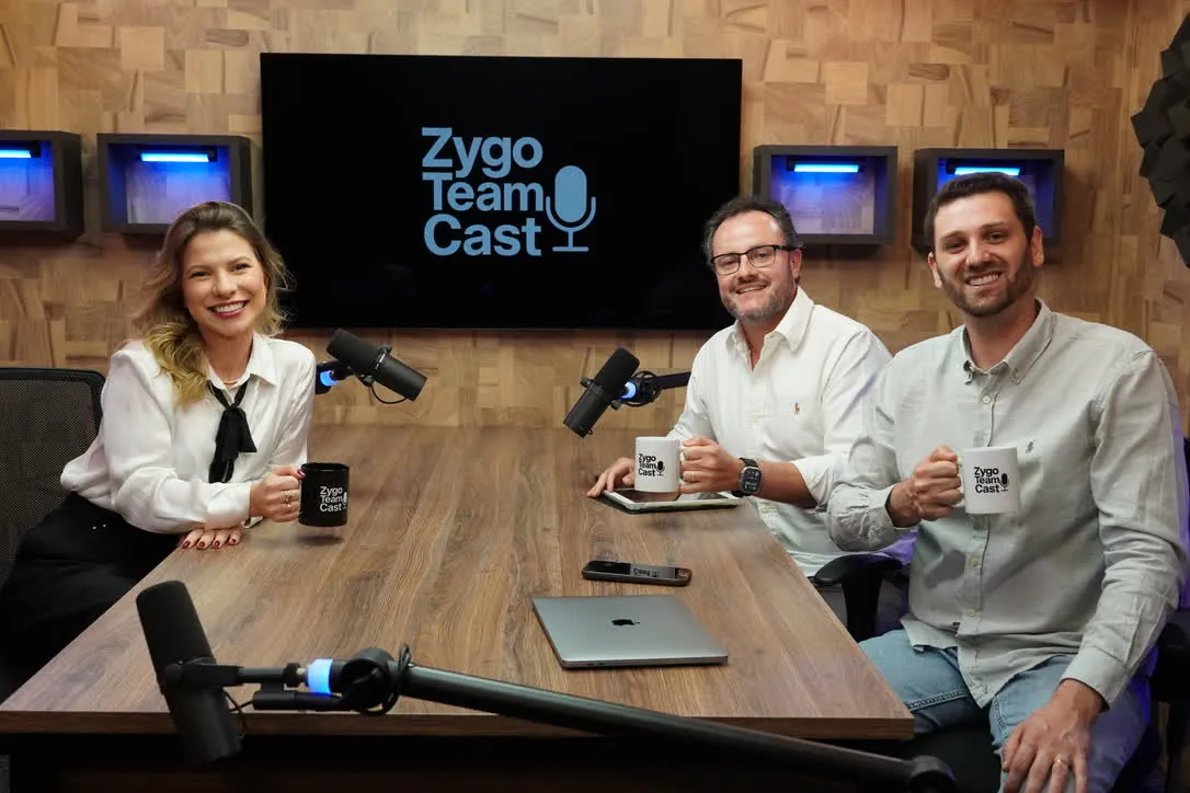 Três pessoas à mesa de gravação do Zygo Team Cast