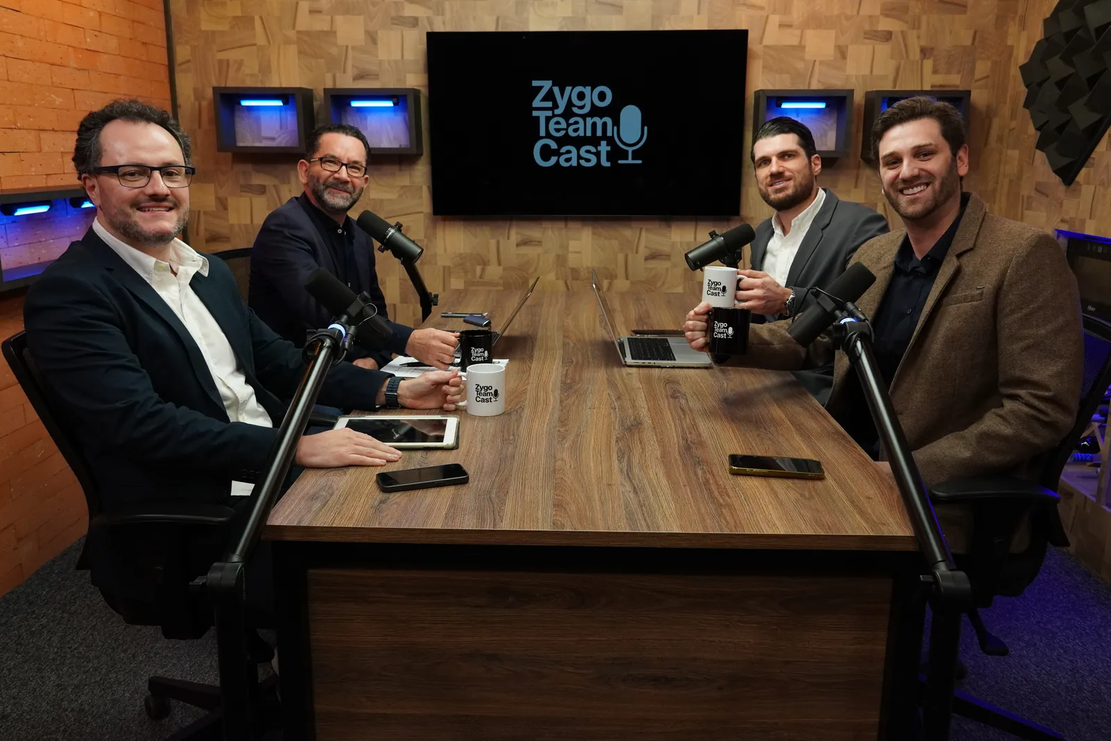 Mesa do estúdio com os apresentadores e um convidado